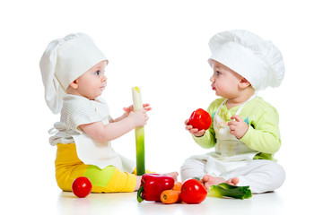 babies boy and girl wearing a chef hat with healthy  food vegeta