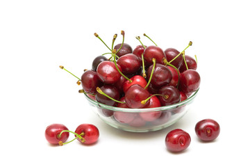 cherries in a glass bowl on a white background