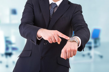 Businessman pointing at his wristwatch.