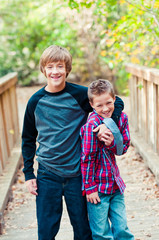 Two boys with little boy getting tickled