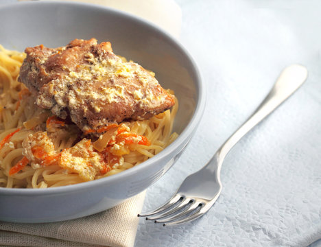 Noodles with rabbit stewed with carrots and onions in sour cream