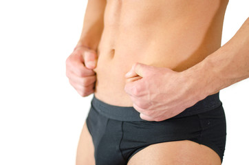 Fit young man pinching his belly skin