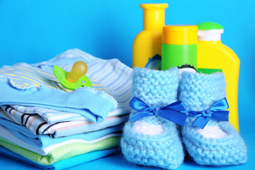 Obraz na płótnie Canvas Pile of baby clothes on blue background