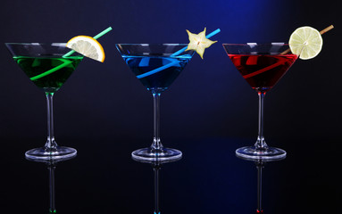 Alcoholic cocktails in martini glasses on dark blue background