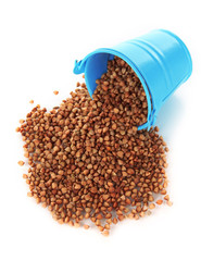 Overturned bucket with grains isolated on white