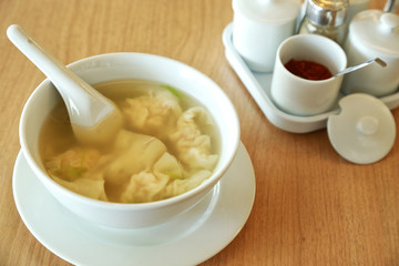 Wonton soup with spoon in a bowl. Traditional asian food