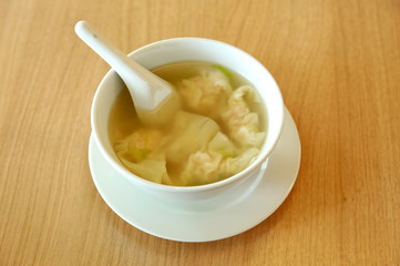 Wonton soup with spoon in a bowl. Traditional asian food