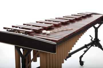 A brown wooden marimba on a white background