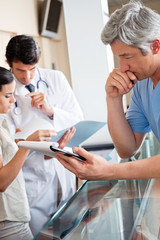 Doctor Reading Document At Reception