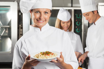 Happy Female Chef Presenting Dish