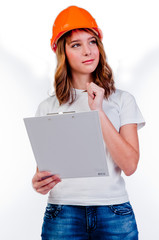 beautiful girl in a building helmet and tools in hand