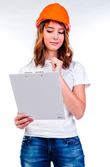 beautiful girl in a building helmet and tools in hand