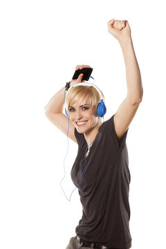 happy girl plays with headphones and music from her phone