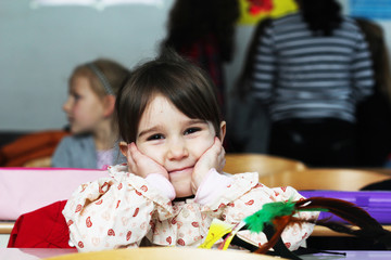 Happy little girl in school with her friends arround