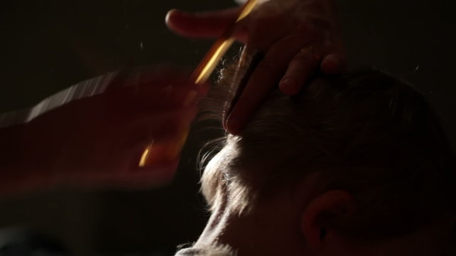 The little boy's hair is being cut.