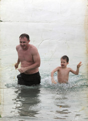 father and son on the sea. Photo in old color image style.