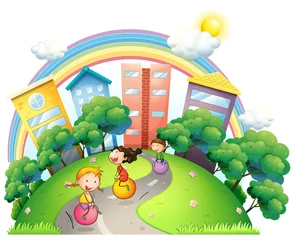 Tuinposter Regenboog Drie meisjes die op straat spelen