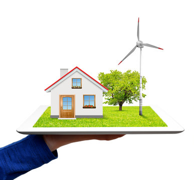 hand holding a tablet with a wind turbine and house