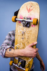 Skater hiding behind his skateboard © LoloStock