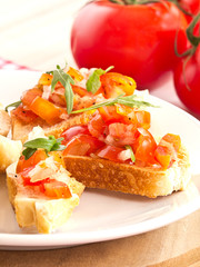 Antipasti aus Tomaten, Ruccola und Zwiebeln.
