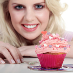 Frau mit Cupcake lächelt vergnügt Nahaufnahme