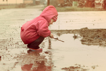little girl playing in the puddle
