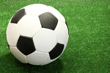 Fototapeta na wymiar Piłka nożna na sztucznej zielonej trawie