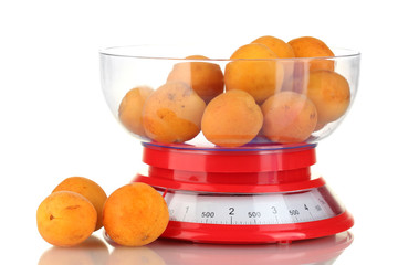Ripe apricots in kitchen scales isolated on white