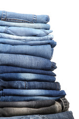 Many jeans stacked in a pile isolated on white