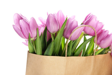 Beautiful bouquet of purple tulips in paper bag, isolated