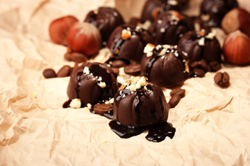 Chocolate candies and coffee beans, on beige paper background