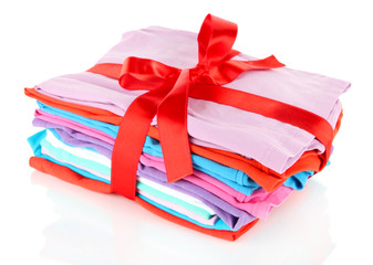 Pile of clothing with red ribbon and bow isolated on white