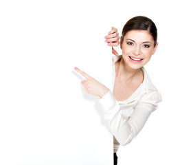 Happy woman points on the white blank banner