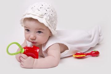 Baby isolated on white playing with rattle
