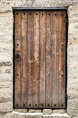 Fotobehang Oude deur Oude houten deur in oude stenen kasteelmuur. Tallinn, Estland
