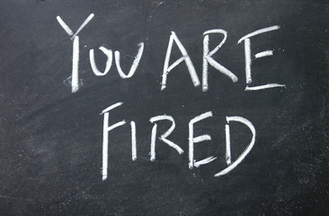 you are fired title written with chalk on blackboard