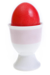 Red easter egg in stand on white background