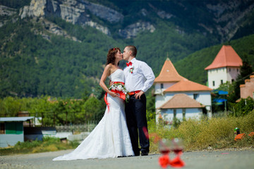 Bride and groom kissing on the background of mountains