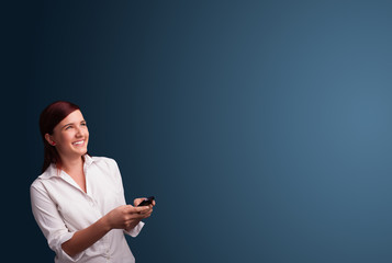 Young woman standing and typing on her phone with copy space