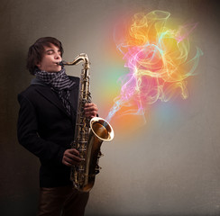Fototapeta na wymiar Atrakcyjne muzyk grający na saksofonie z kolorowych abstrakcyjny