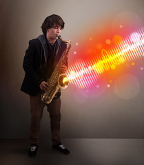 Young man playing on saxophone with colorful sound waves