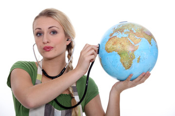 Fototapeta premium HOLDING, STETHOSCOPE ON GLOBE