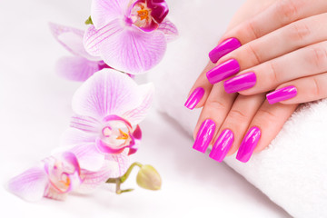 Obraz na płótnie Canvas female manicure with pink orchid and towel