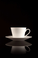 White coffee cup on black reflective surface