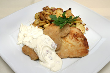 Schnitzel mit Bratkartoffeln und einer herzhaften Schmandsauce