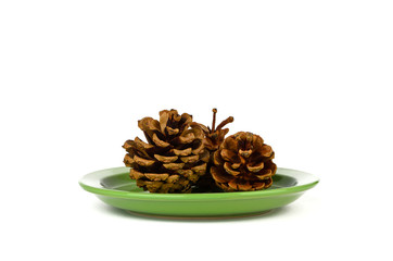 Three fir cones on a green plate