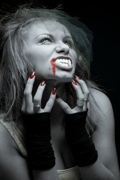 woman vampire with fangs on a black background