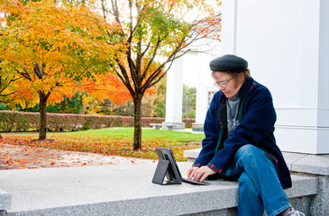 Woman typing on a wireless keyboard in autumn