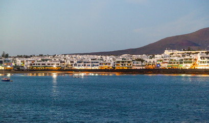 town and harbor of Playa Blanca from seaside in the evening