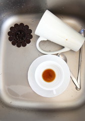 Dishwashing. White dishes in the kitchen sink.